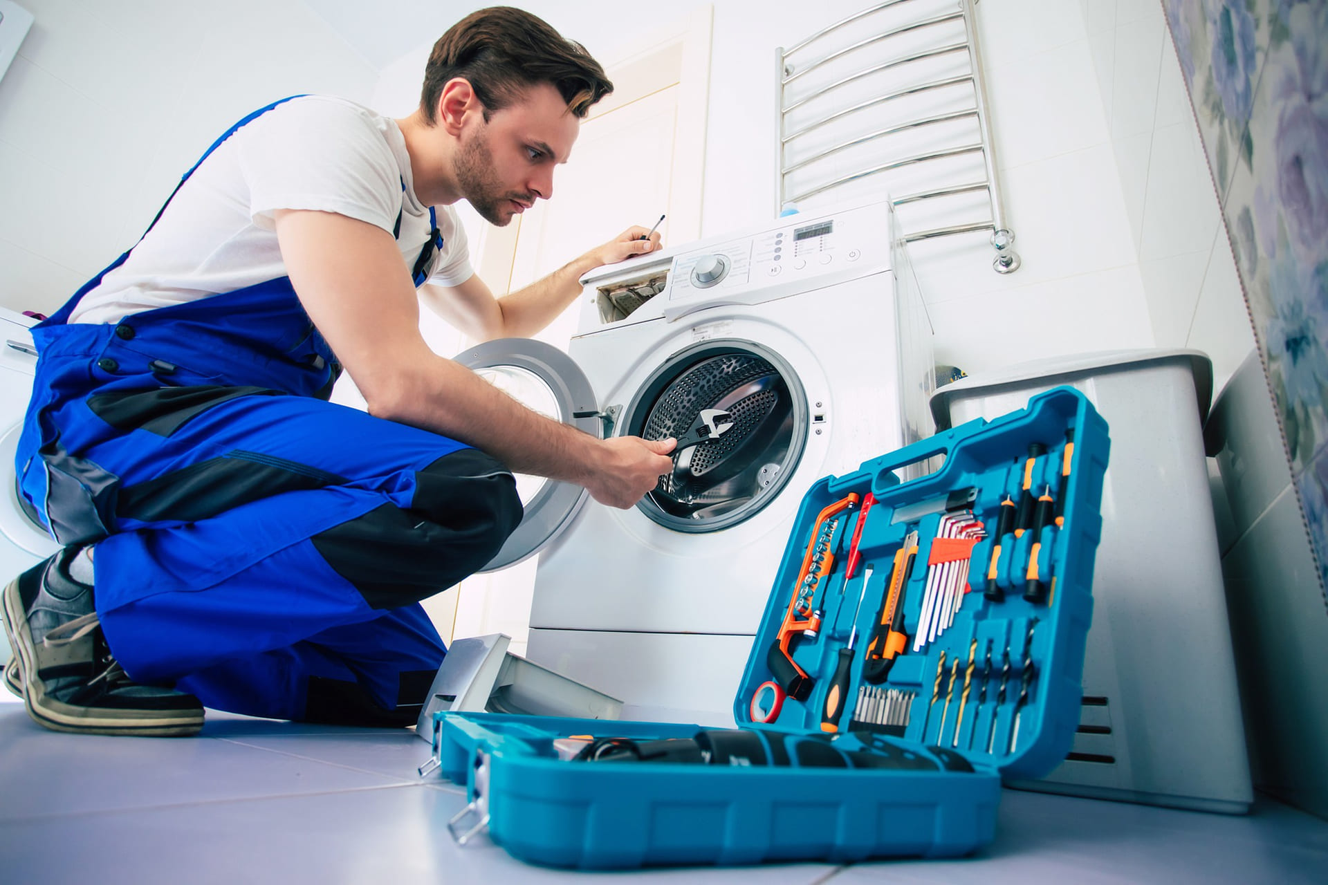 young-handsome-repairman-worker-suit-with-professional-tools-box-is-fixing-washing-machine-bathroom